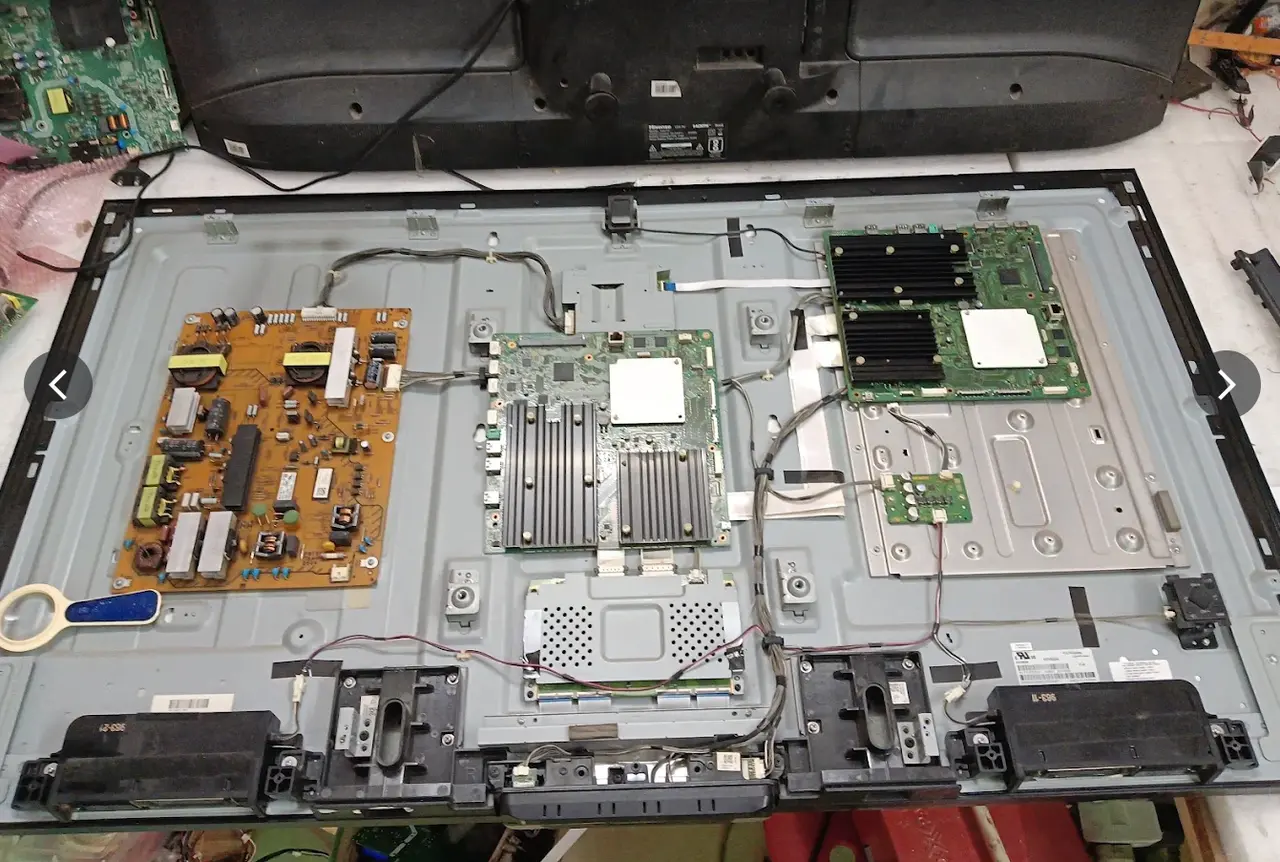 TV opened for chip-level motherboard repair — full photo without crop